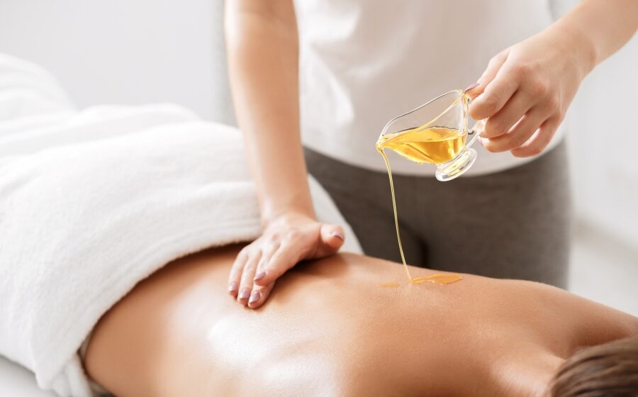 Eine Person massiert eine andere Person und verwendet dabei Massageöl.
